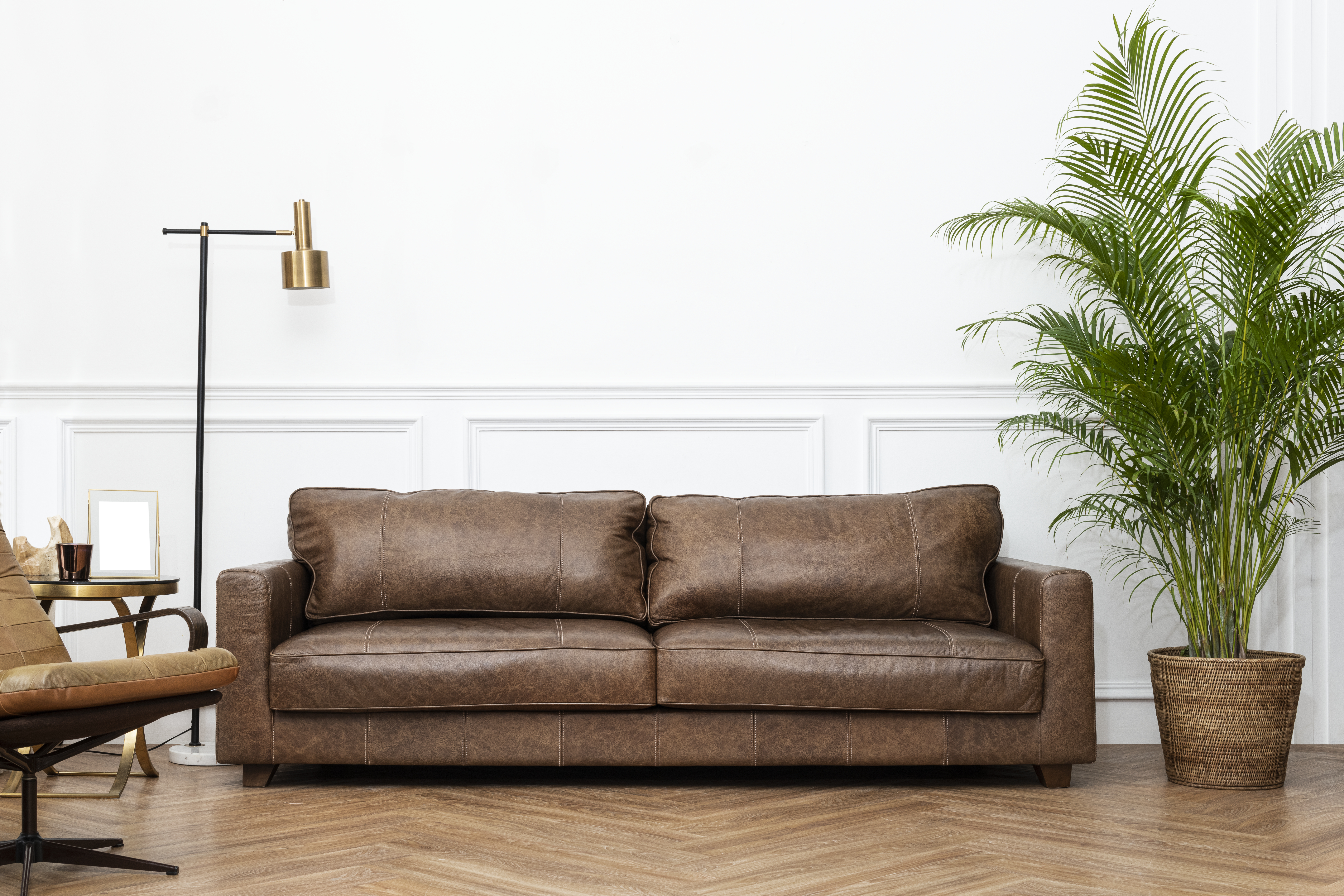 A modern sofa styled with neutral-toned cushions and a cozy throw, showcasing a warm and inviting living room setup by Nested.pk.